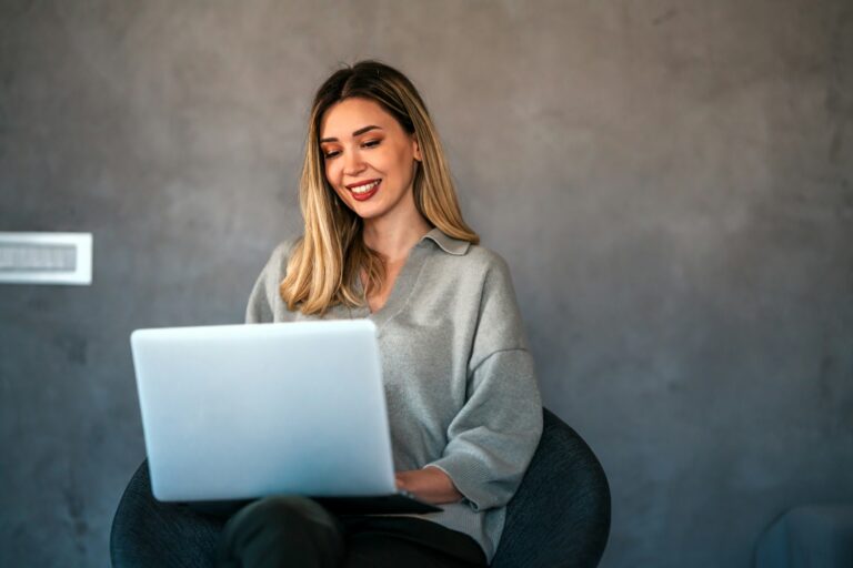 Young female designer, freelancer working in the office. Female using laptop to searching info.